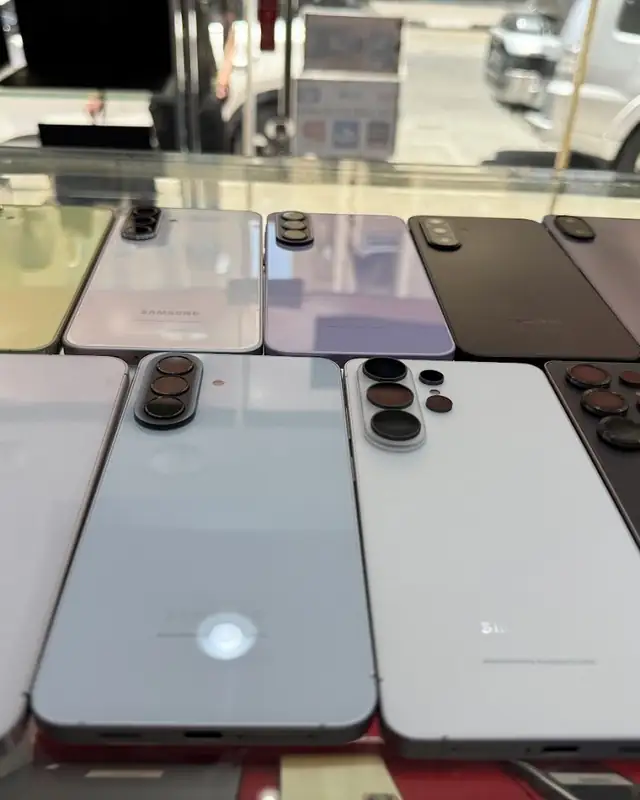 Customer holding a phone in front of the accessories wall