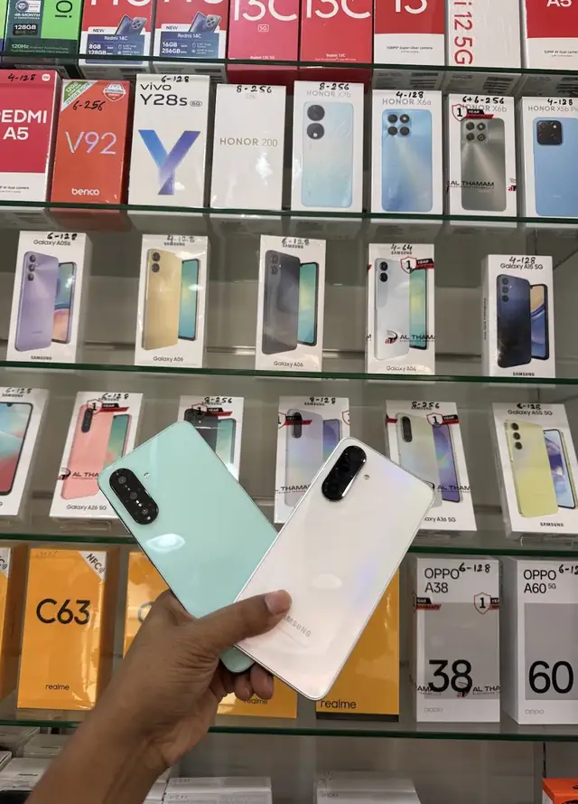 Phones held up in front of a wall of phone boxes